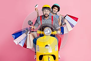 Portrait of his he her she nice attractive cheerful customers driving moped carrying buyings new things center mall photo