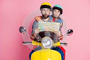 Portrait of his he her she nice attractive funny amazed couple driving moped searching address on paper map way rout