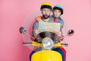 Portrait of his he her she nice attractive funny amazed couple driving moped searching address on paper map way rout photo