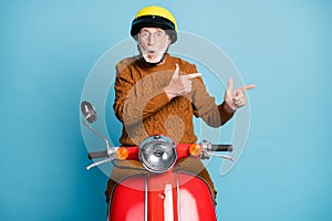 Portrait of his he nice attractive amazed stunned astonished bearded grey-haired man riding moped showing copy space