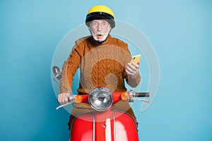 Portrait of his he nice attractive amazed stunned bearded grey-haired man riding moped using gadget pout lips social