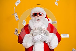 Portrait of his he nice attractive amazed stunned fat overweight bearded Santa holding in hand throwing usd 100 fan cash