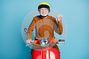 Portrait of his he nice attractive cheerful bearded grey-haired man father riding moped pointing thumb aside copy empty