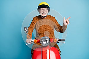 Portrait of his he nice attractive cheerful cheery bearded grey-haired man riding moped showing copy empty blank place