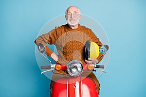 Portrait of his he nice attractive cheerful cheery content bearded grey-haired man riding moped having fun rental