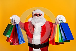 Portrait of his he nice attractive cheerful cheery fat Santa holding in hands carrying things buyings retail store photo