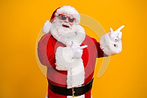 Portrait of his he nice attractive cheerful cheery fat Santa pointing presenting copy space newyear party idea shopping