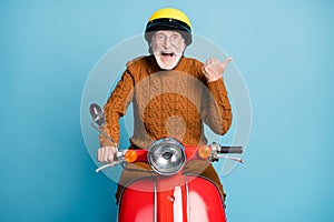 Portrait of his he nice attractive cheerful cheery glad amazed bearded grey-haired man father riding moped pointing