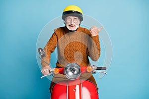 Portrait of his he nice attractive cheerful cheery glad bearded grey-haired man father riding moped demonstrating advice