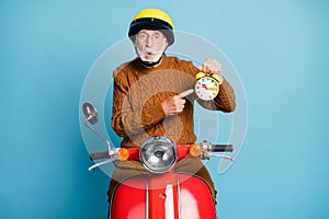 Portrait of his he nice attractive funky amazed stunned wondered bearded grey-haired man riding moped holding in hand