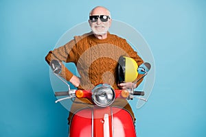 Portrait of his he nice attractive funky cheerful cheery content cool bearded grey-haired man hipster sitting moped