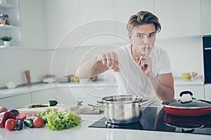 Portrait of his he nice attractive lovely cute guy making organic lunch dinner salting boiling bouillon water at light