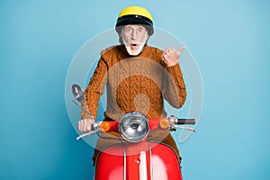Portrait of his he nice attractive stunned amazed bearded grey-haired man father riding moped pointing thumb aside copy