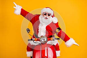 Portrait of his he nice childish playful cheerful cheery Santa riding moped fooling having fun like plane fly air flight