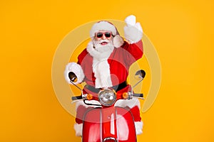 Portrait of his he nice cool cheerful cheery lucky Santa riding moped celebrating rejoicing accomplishment isolated