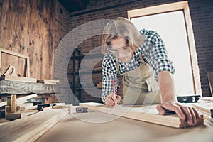 Portrait of his he nice handsome blond serious focused guy expert skilled woodworker measuring board furniture shop at