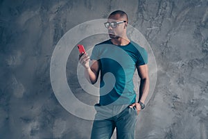 Portrait of his he nice lovely attractive sporty good-looking focused guy wearing blue t-shirt using new gadget chatting