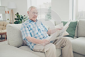 Portrait of his he single nice focused concentrated peaceful calm granddad sitting on divan reading world news paper in