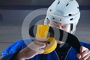 Portrait of Hockey player taping his stick