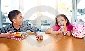 Portrait, home and kid with candy, eating and brother with vegetables, healthy food and breakfast. House, child and