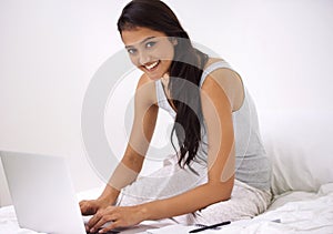 Portrait, home and woman with a laptop, bedroom and typing with internet, technology and connection. Face, person and
