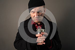 Portrait of a homeless dirty young man holding canned food. The concept of an unemployed beggar man