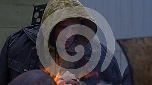 Portrait of Homeless man in front of a fire, close up