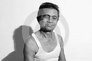 Portrait of a homely asian senior man smiling at the camera, black and white photo concept