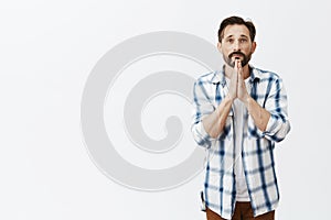 Portrait of hopeful relaxed and believing caucasian man, holding hands in pray and making wish, talking with god, hoping