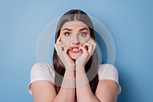 Portrait of horrified afraid scared lady gnaw nails look camera on blue background