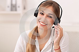 Portrait Of Hotline Operator In Headset Smiling Sitting In Office