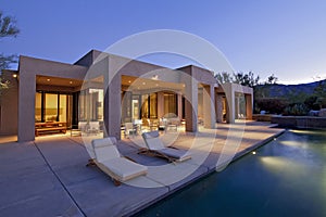 Portrait of House exterior with pool at dusk