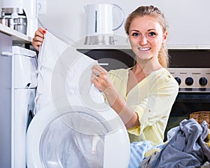 Portrait of housewife taking clothes out washing machine