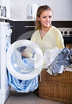 Portrait of housewife taking clothes out washing machine