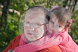 A portrait of a hugging father and daughter