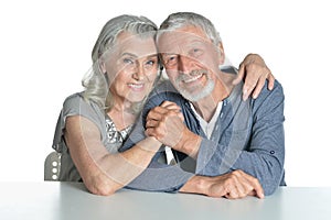 Portrait of hugging senior couple sitting at table