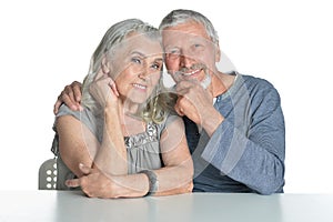 Portrait of hugging senior couple sitting at table