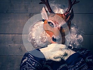 Portrait of human in a deer mask and winter clothes, careful th