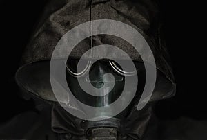 Portrait of human in gas mask and hood on black backdrop. Concept ecology protection. Radiaton, biohasard pollution concept.