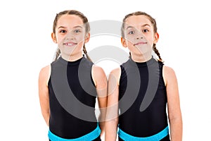 Portrait of identical twin girls dressed in rhythmic gymnastics dress