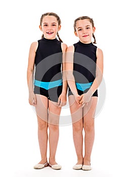 Portrait of identical twin girls dressed in rhythmic gymnastics dress