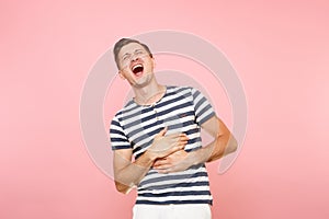 Portrait of ill painful young man in striped t-shirt put his hands on stomach with stomachache or gastroenterologists