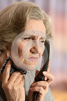 Portrait of ill senior woman calling doctor