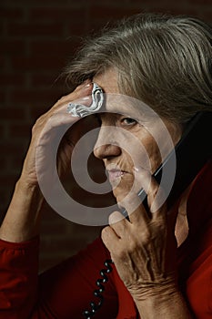 Portrait of ill senior woman calling doctor