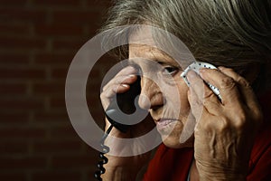 Portrait of ill senior woman calling doctor