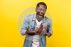 Portrait of ill stressed man grimacing from unbearable pain. indoor studio shot  on yellow background