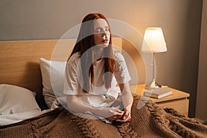 Portrait of ill young woman suffering from runny nose disease, paper tissues inserted into nose, eyes closed.