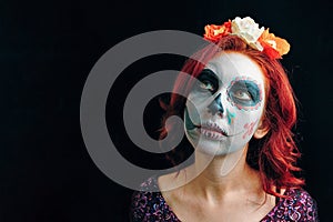 A young woman in day of the dead mask skull face art.