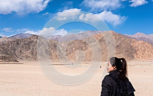 Portrait image of a beautiful Asian woman tourist standing in front of mountain