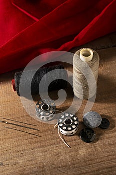 Portrait image of stitching tools on wooden board and red cloth